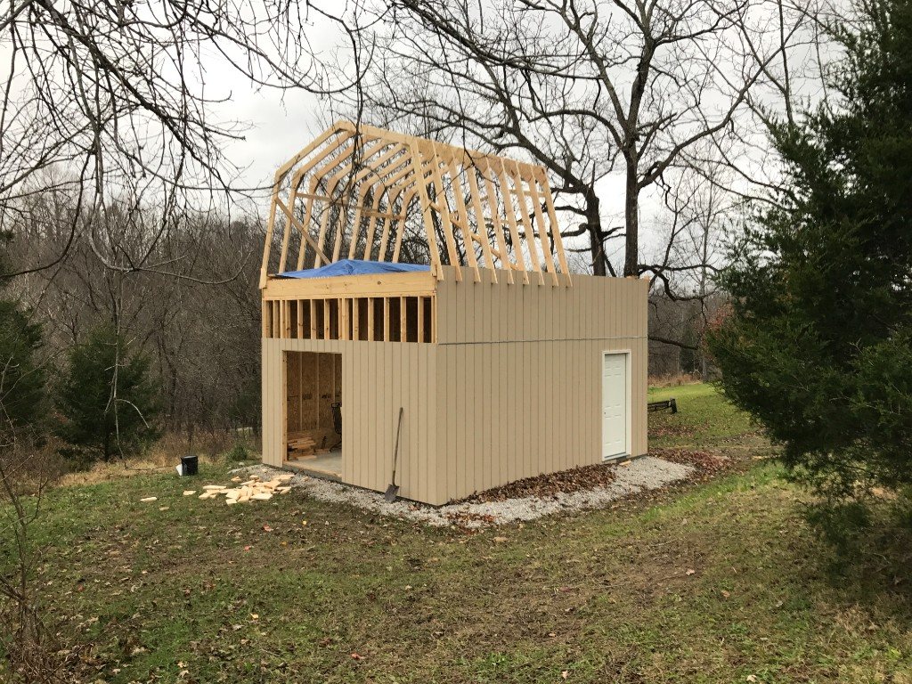 Gambrel barn with tan siding under construction