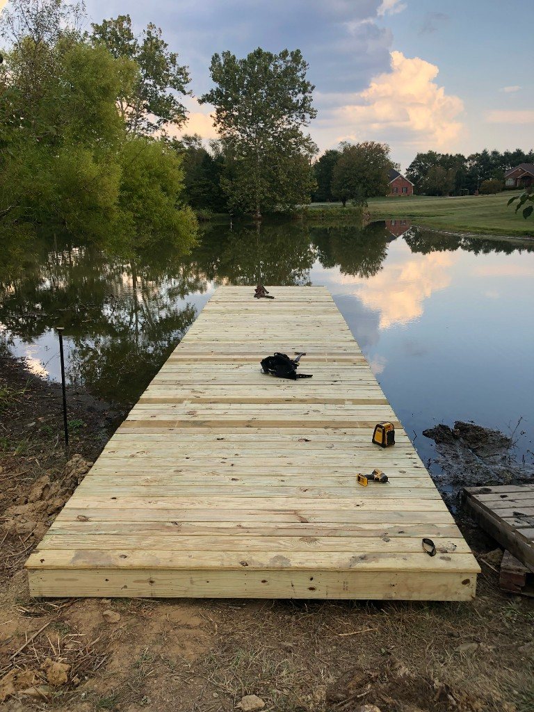 Wooden dock extending into a pond at dusk