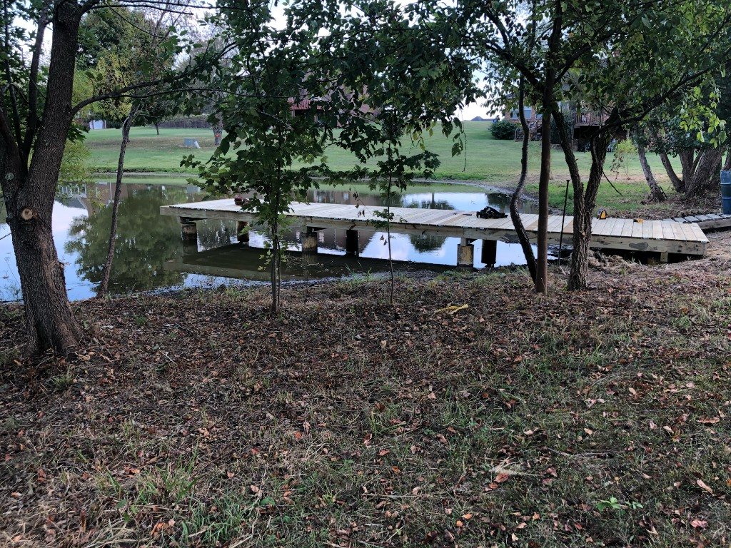 Finished wooden dock extending over a calm pond