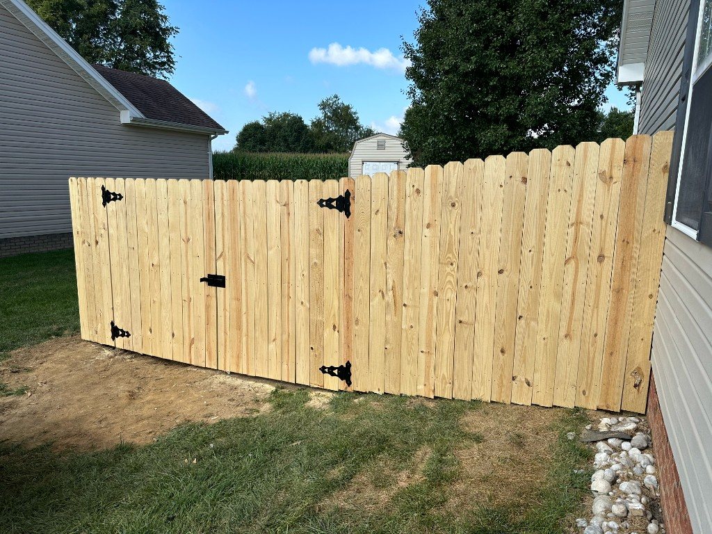 Wooden privacy fence with decorative double gate