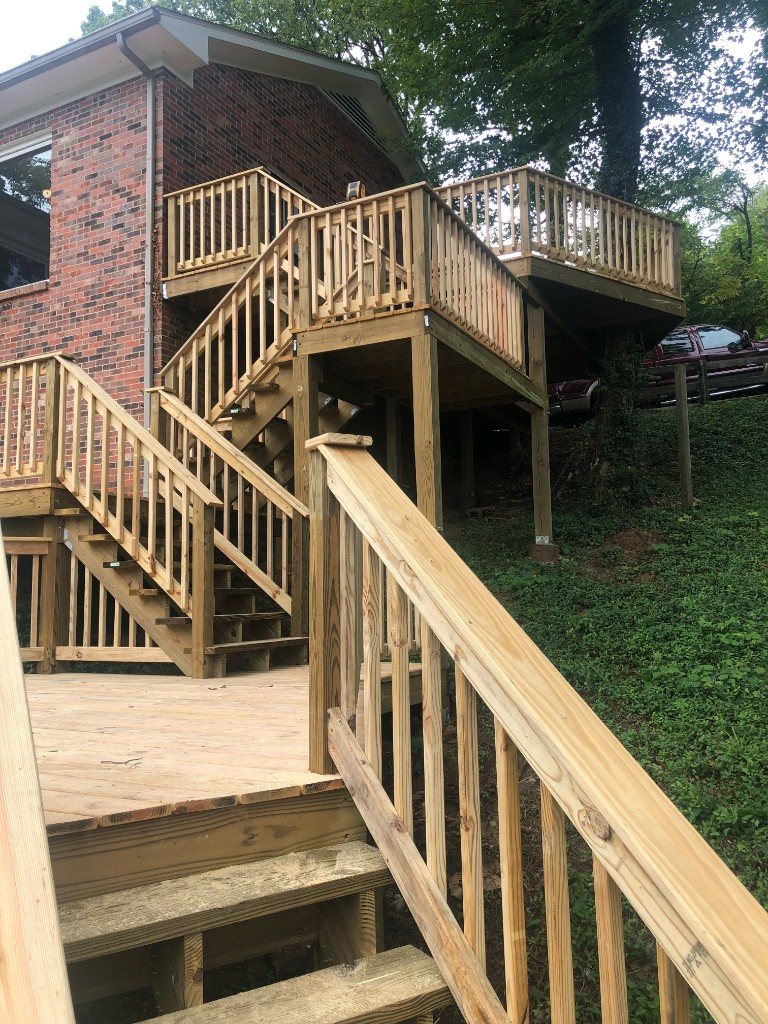 Multi-level deck with stairs down a wooded hillside