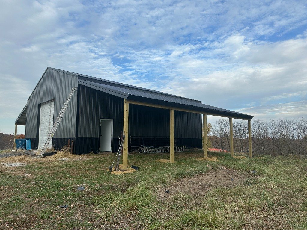 Finished lean-to with metal roof attached to a metal workshop