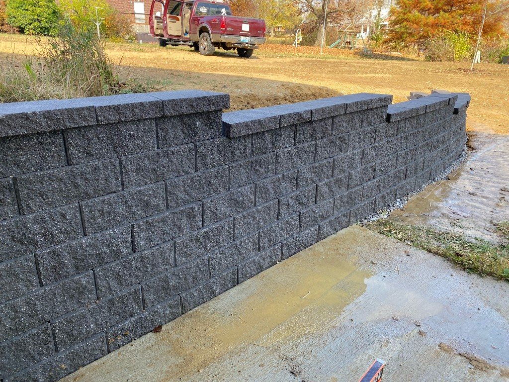 Curved segmental stone retaining wall with capstones